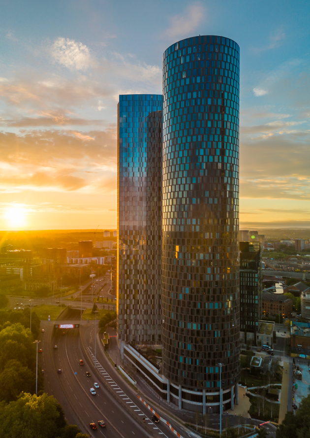 Three60 cylindrical residential tower at sunset in Manchester